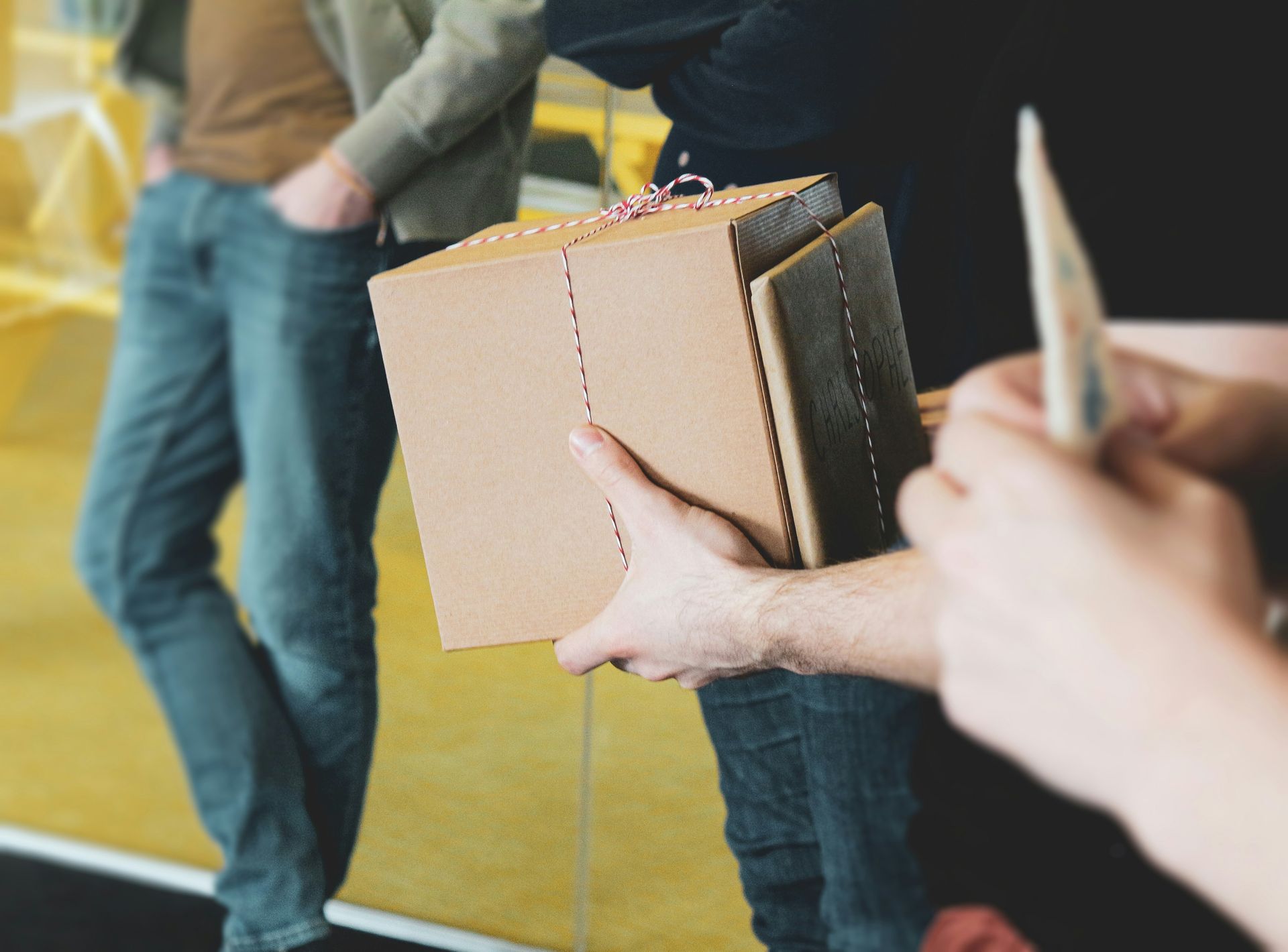 a person holding a brown box with a string on it